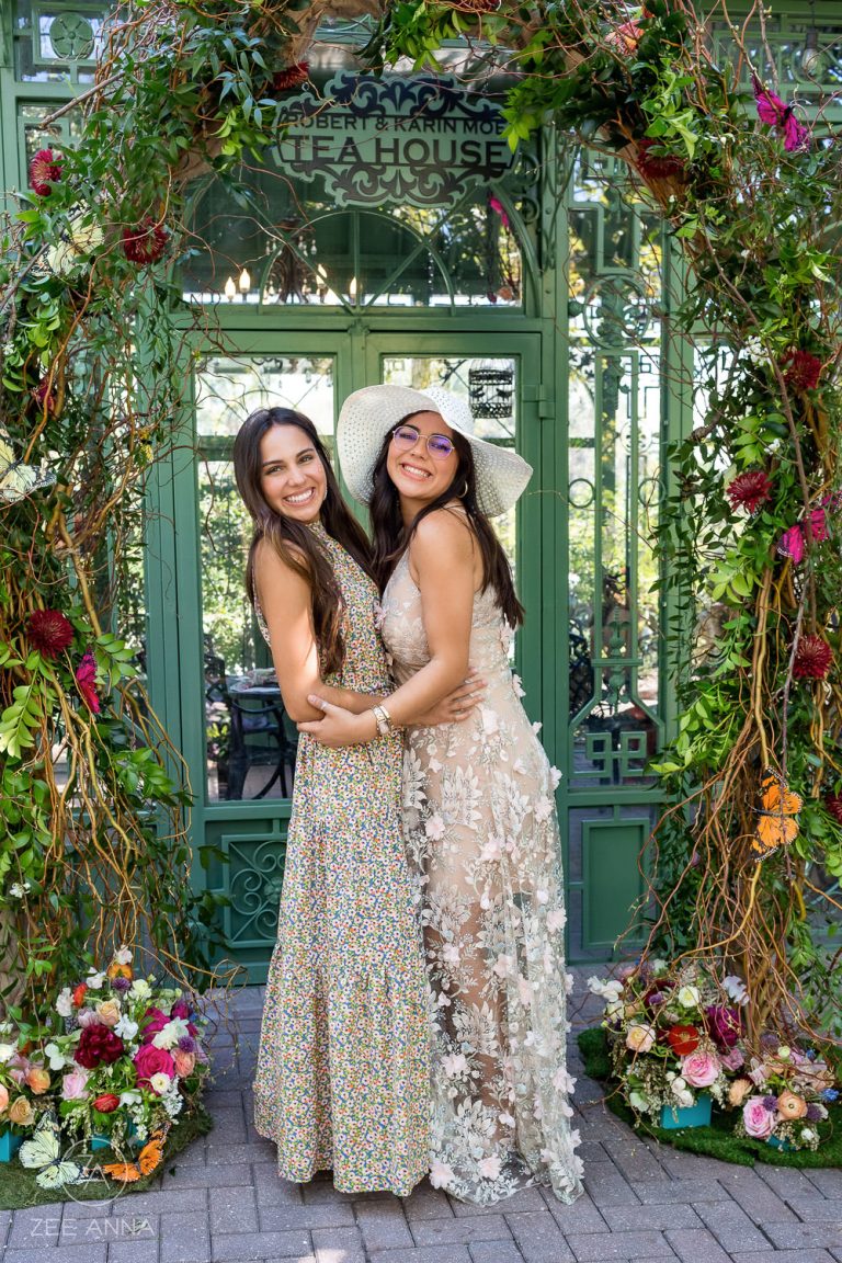 Two well-dressed women posing at a tea party - photo by Zee Anna Photography