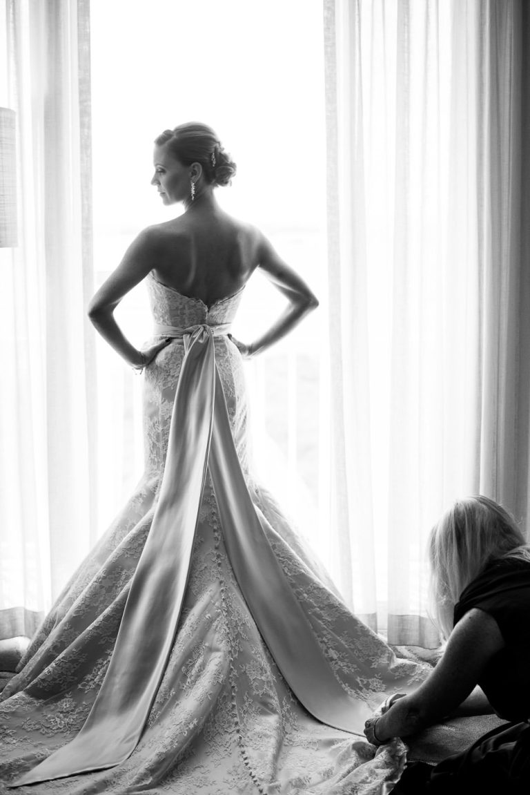 Black and white photo of an elegant bride getting dressed - photo by Zee Anna Photography